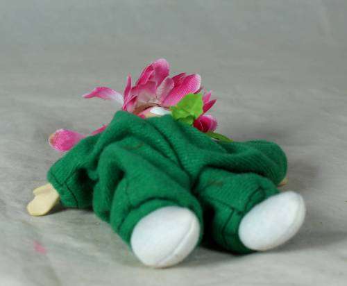 porcelain and cloth clown dressed in a green jump suit