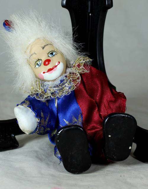 Porcelain and cloth clown dressed in a blue and purple jump suit