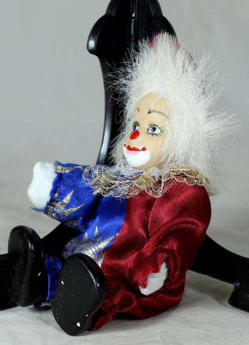 Porcelain and cloth clown dressed in a blue and purple jump suit