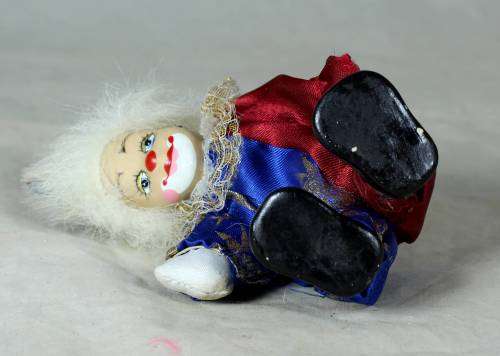 Porcelain and cloth clown dressed in a blue and purple jump suit