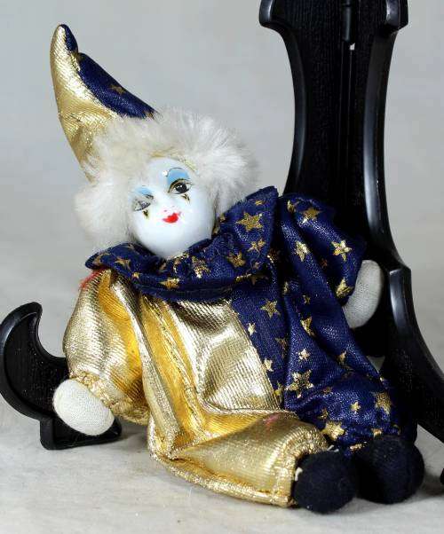 Porcelain and cloth clown dressed in blue and gold