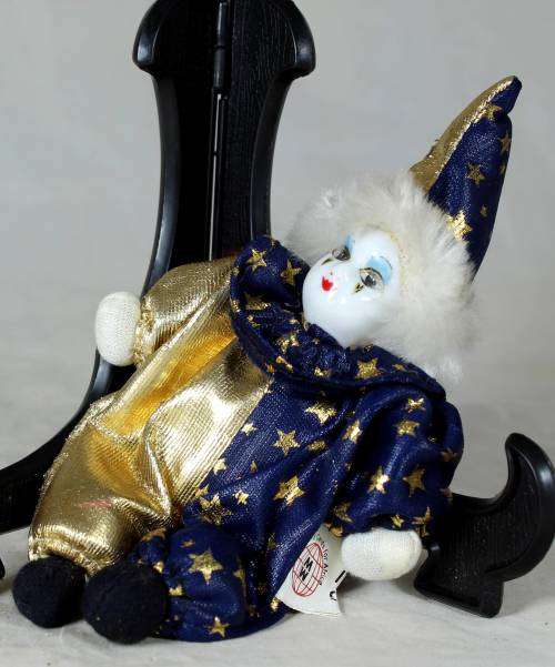 Porcelain and cloth clown dressed in blue and gold