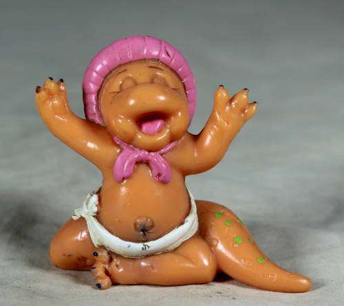 Nappy baby dinosaur wearing a pink bonnet