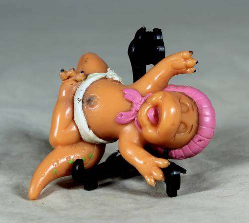 Nappy baby dinosaur wearing a pink bonnet
