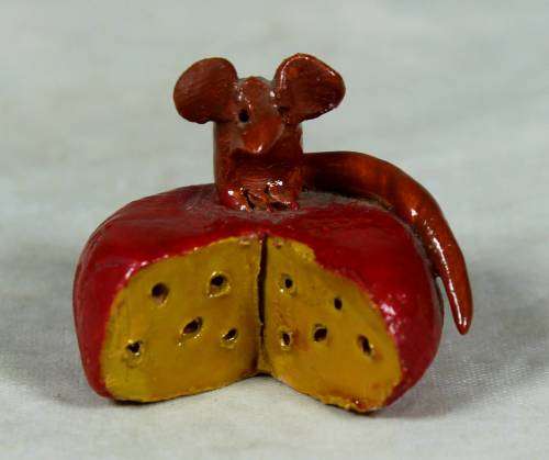 Miniature mouse on a cheese wheel
