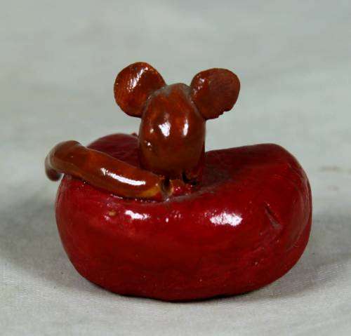Miniature mouse on a cheese wheel