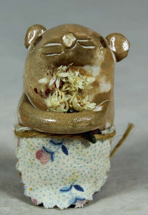 Carved stone mouse holding flowers