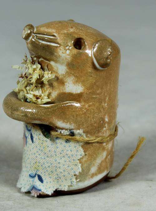 Carved stone mouse holding flowers