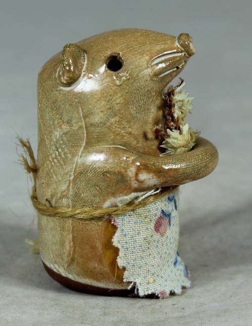 Carved stone mouse holding flowers