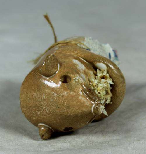 Carved stone mouse holding flowers