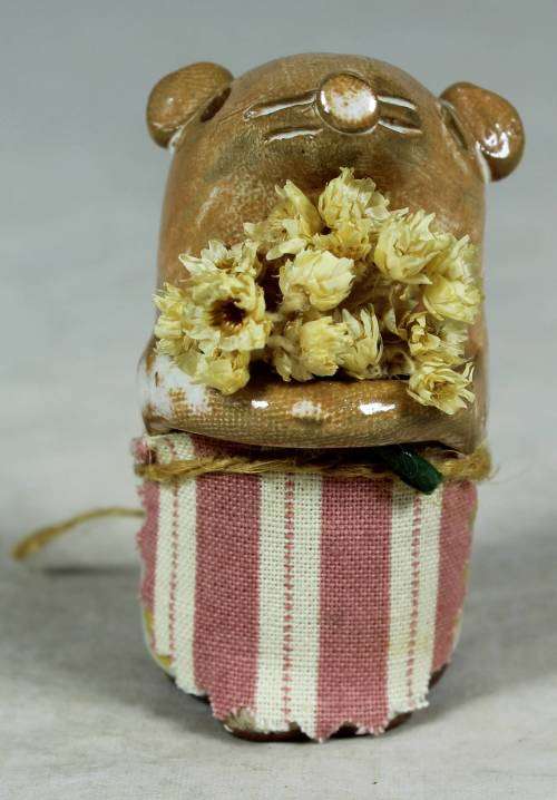 Carved stone mouse holding flowers