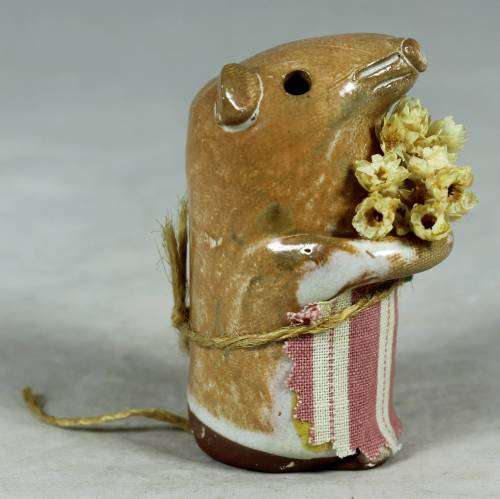 Carved stone mouse holding flowers