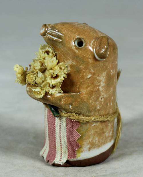 Carved stone mouse holding flowers