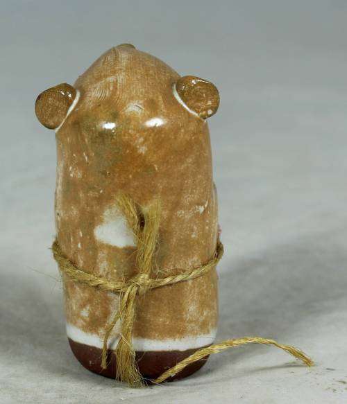 Carved stone mouse holding flowers