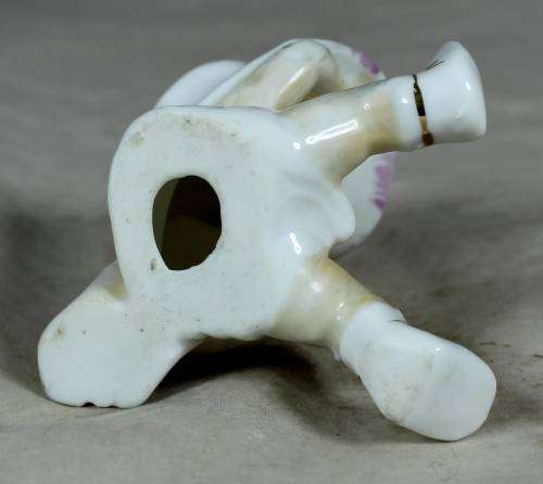 Porcelain sitting cowgirl with a pink gun belt