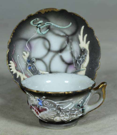 Miniature porcelain cup and saucer with a dragon
