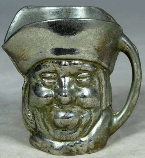 Small metal jug with a face
