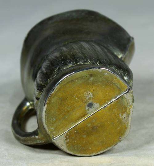 Small metal jug with a face