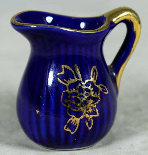 Miniature blue porcelain jug with a gold flower