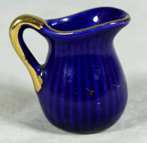 Miniature blue porcelain jug with a gold flower