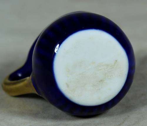 Miniature blue porcelain jug with a gold flower