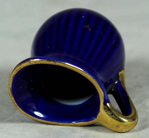 Miniature blue porcelain jug with a gold flower