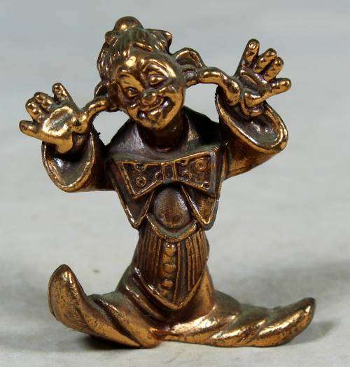 Miniature brass color lead clown with his fingers in his ears