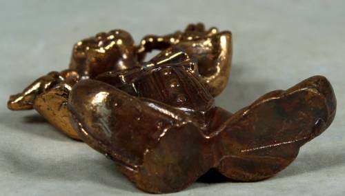 Miniature brass color lead clown with his fingers in his ears