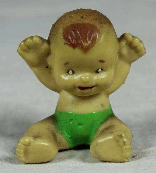 Miniature baby with her arms in the air