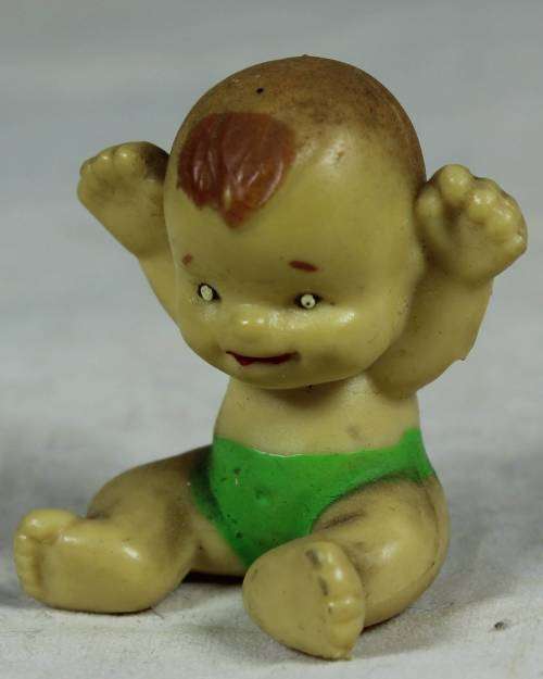 Miniature baby with her arms in the air