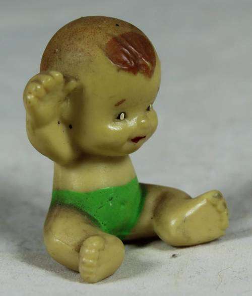 Miniature baby with her arms in the air