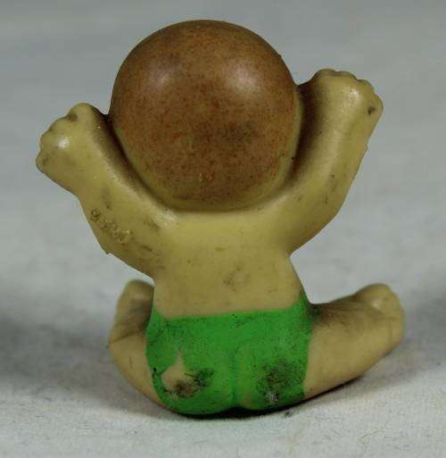 Miniature baby with her arms in the air