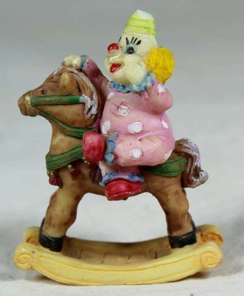Miniature baby clown on a rocking horse