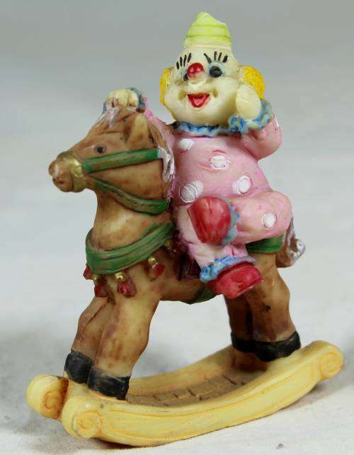 Miniature baby clown on a rocking horse