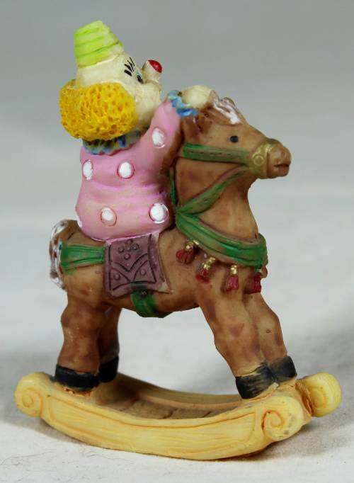 Miniature baby clown on a rocking horse