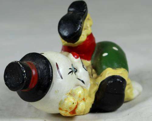 Miniature clown on his back with his foot in the air