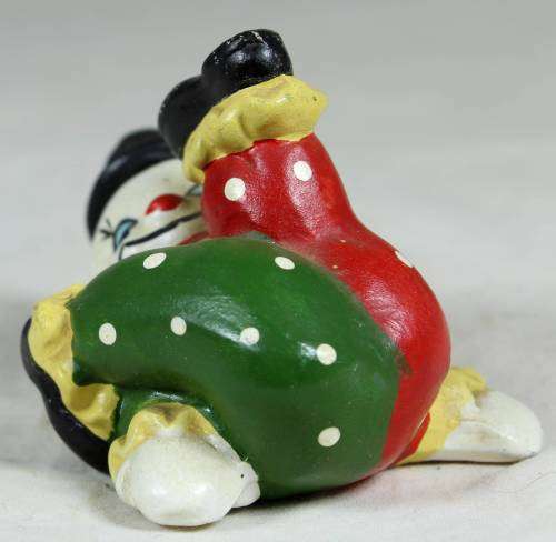 Miniature clown on his back with his foot in the air