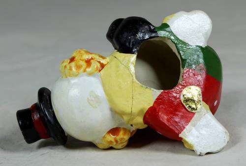 Miniature clown on his back with his foot in the air