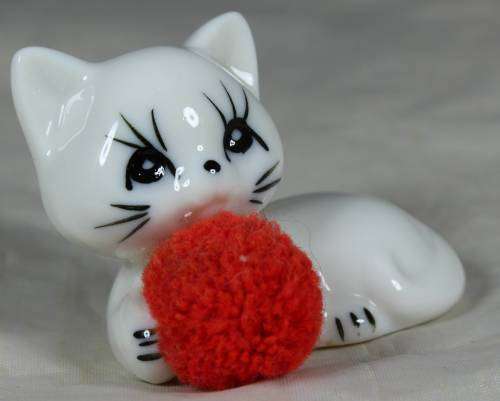 Porcelain cat with a fluffy ball