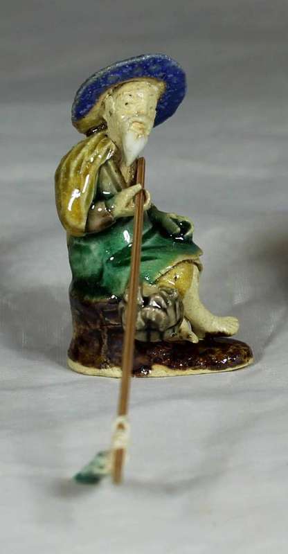 Mud Men - Old man seated & fishing in a blue hat