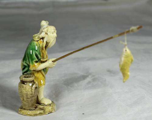 Mud Men - Old man holding a fish and hat