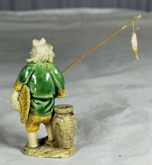 Mud Men - Old man holding a fish and hat