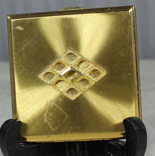 Powder compact with raised rhombus