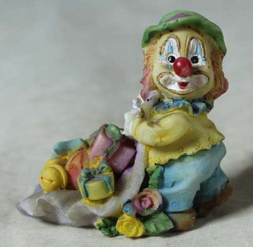 Miniature clown with presents on a large leaf