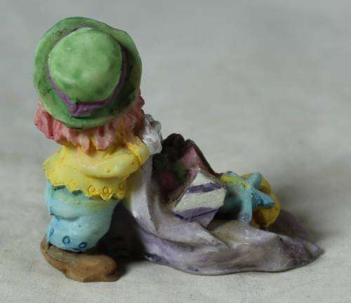 Miniature clown with presents on a large leaf