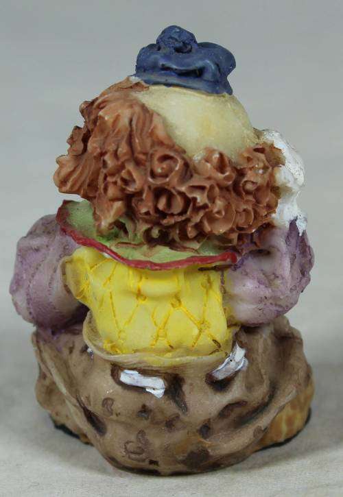 Miniature clown seated scratching his head