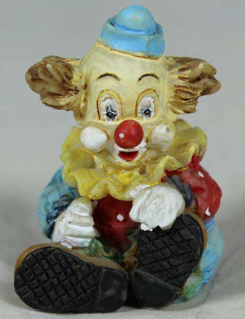 Miniature clown seated holding his shoe