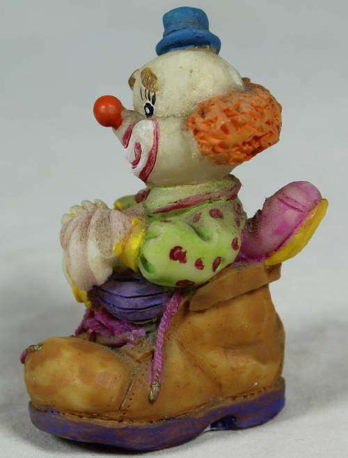 Miniature clown sitting in a shoe