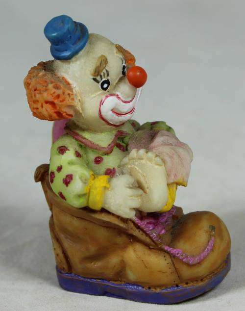 Miniature clown sitting in a shoe