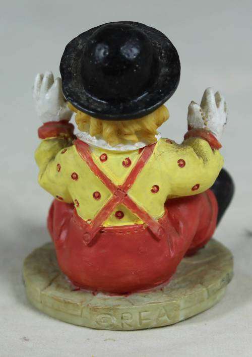 Miniature seated clown with raised hands
